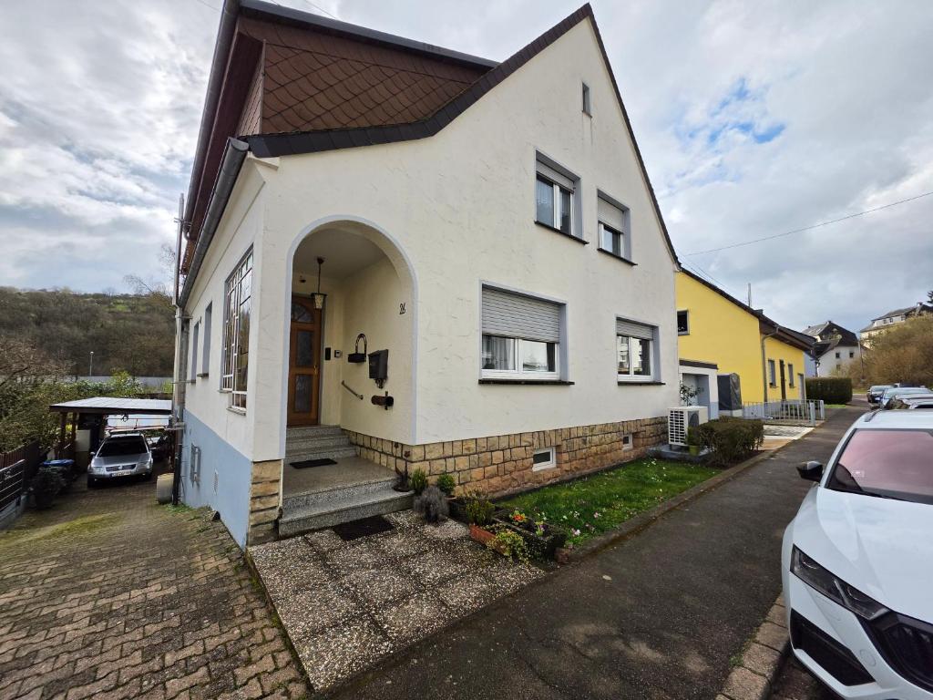 a white house with a door and a driveway at Haus Perla in Saarburg