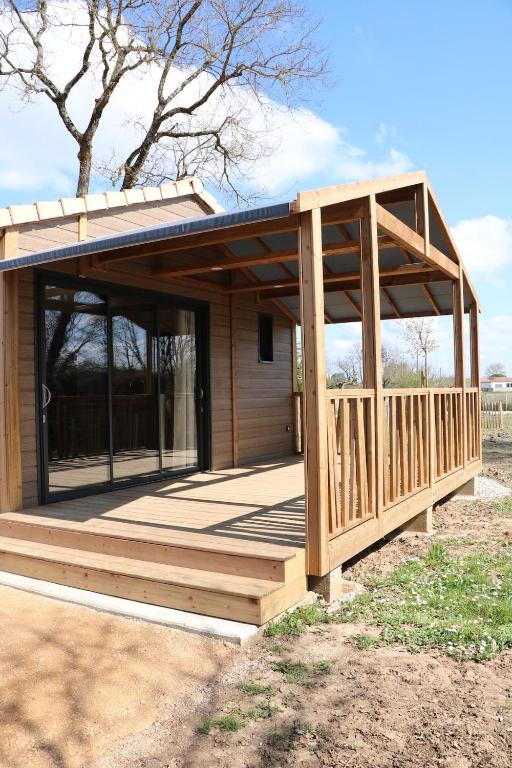 a wooden pavilion with a porch and a building at Chalet Confort 49 in Rivières