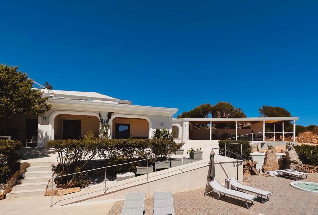 a white house with stairs and benches in front of it at Domo s'Altura in Porto Rotondo