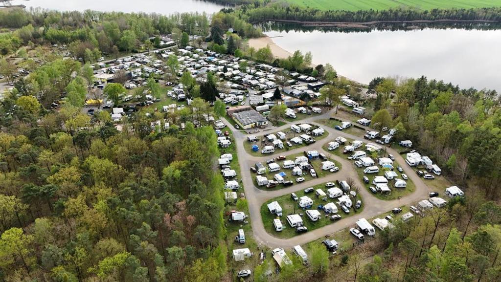 an aerial view of a parking lot next to a lake at Themencamping Grünewalder Lauch in Grünewalde