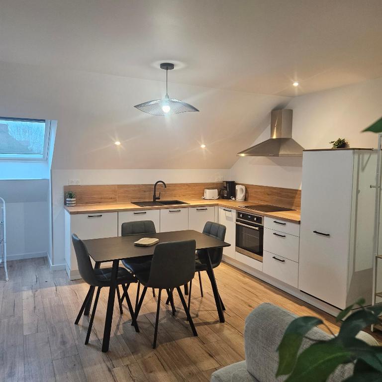 a kitchen with a table and chairs and a sink at Lila in La Chapelle-de-Brain