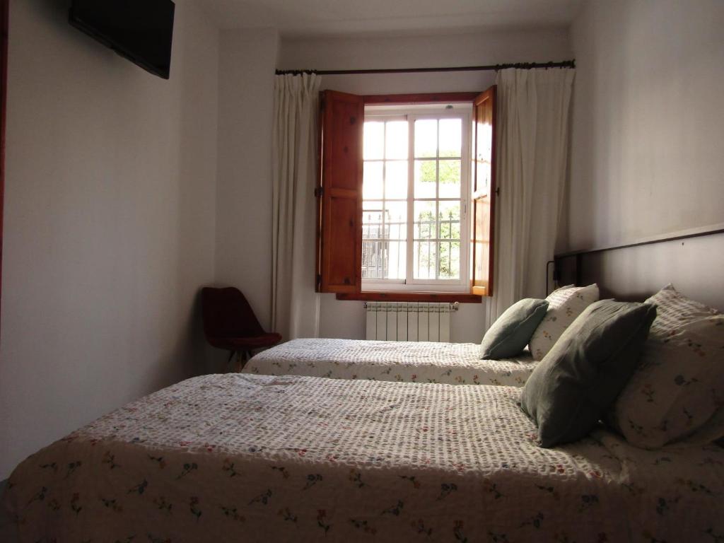 a bedroom with two beds and a window at A Casa de Chelo in Palas de Rei