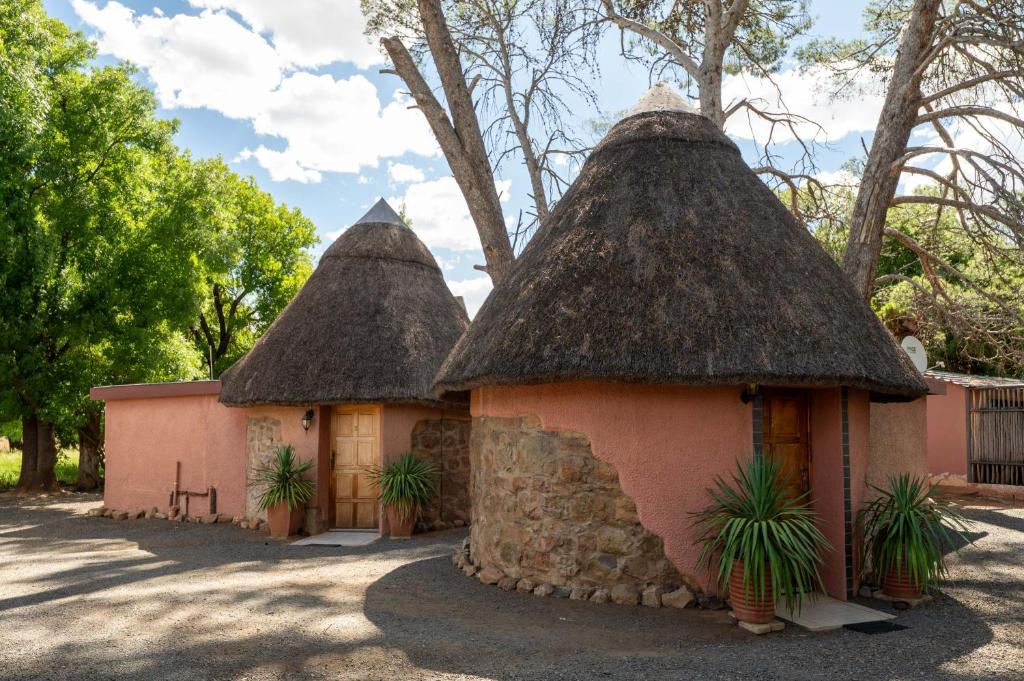 two small huts with thatched roofs in a yard at Van Zylsvlei - A Karoo Guest Farm in Colesberg