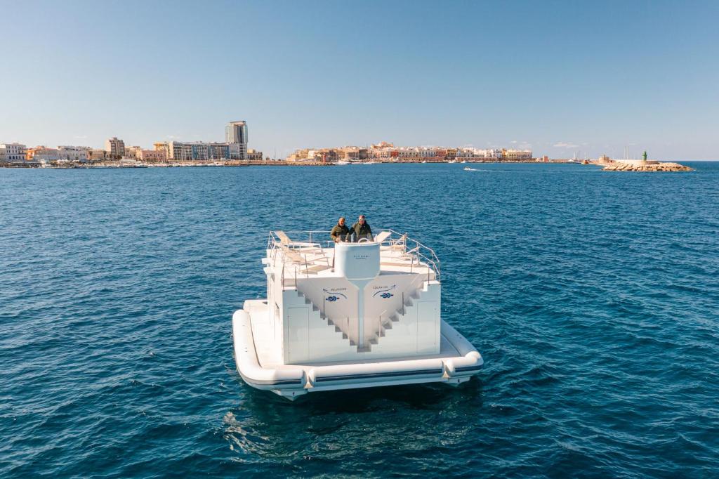 a boat in the water with two people on it at Due Nodi by BarbarHouse in Gallipoli