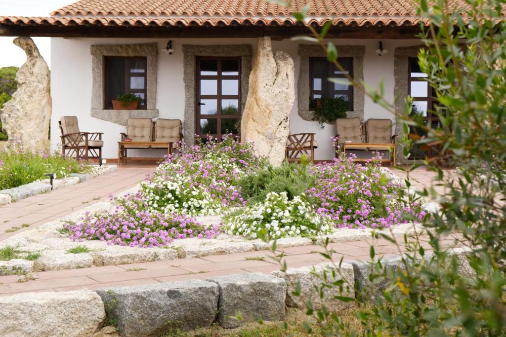 a garden in front of a house with flowers at Villamarina in Aglientu