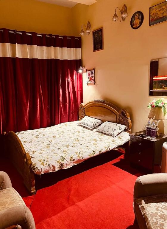 a bedroom with a bed and a red carpet at spice villa hotel in Gajar