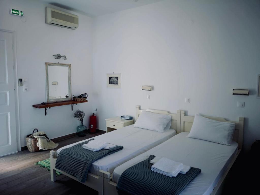 a bedroom with two beds and a mirror on the wall at Fotinis Apartment in Kalymnos