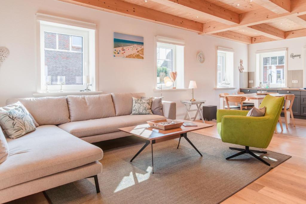 a living room with a couch and a table at Tills Hüs in Utersum