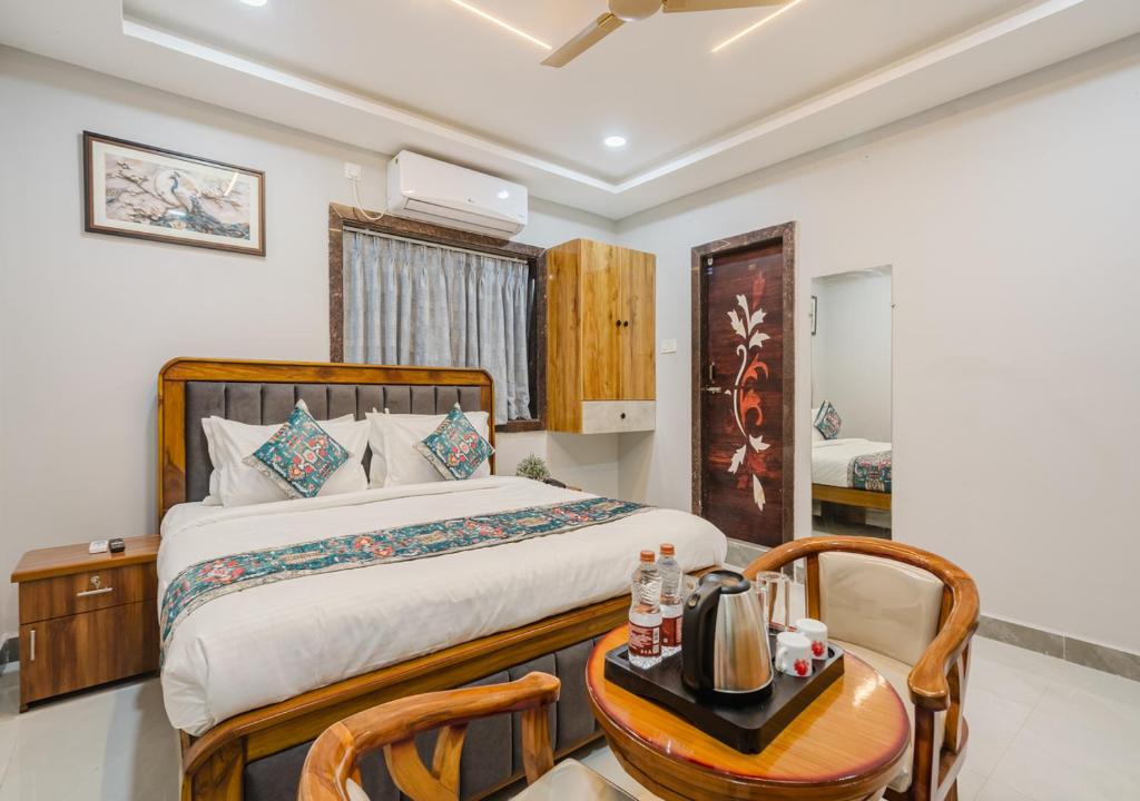 a bedroom with a bed and a table and chairs at Hotel Prestige Grand, Manikonda in Haidar Sāhibgūda