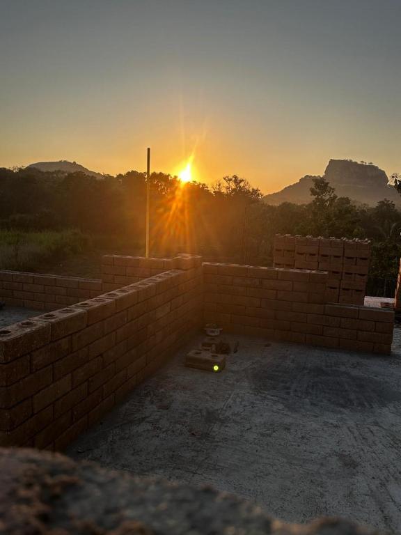 a brick wall with the sunset in the background at The Sigiriya Rock Gate Chalet in Sigiriya