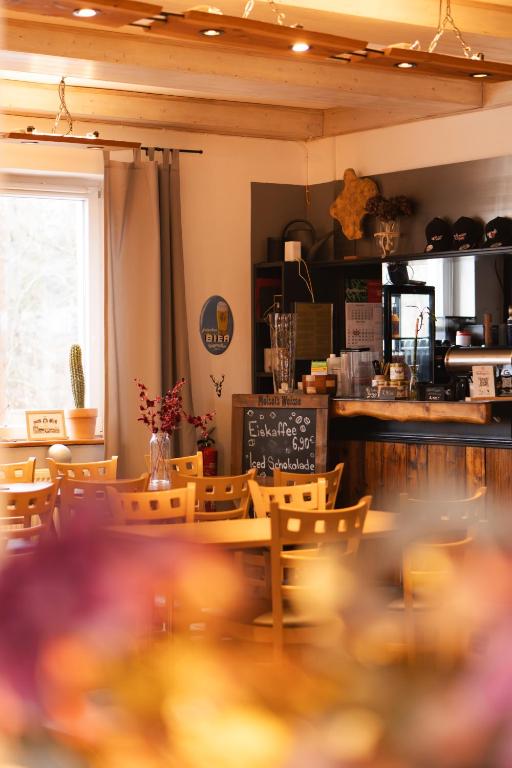 a restaurant with a table and chairs and a counter at Bullhead House in Warmensteinach
