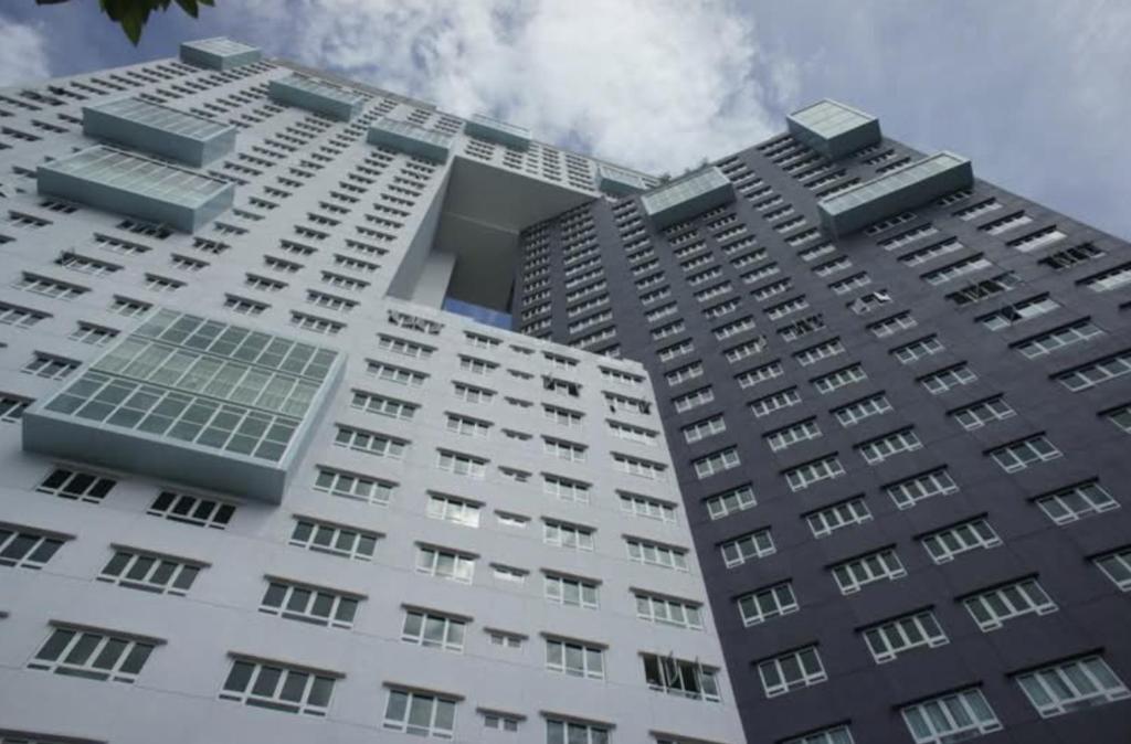 a tall white building with windows on top of it at Pearl Regency Super Condominium in Gelugor