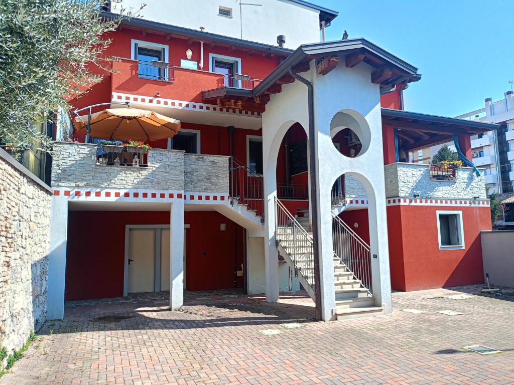 a red and white building with a staircase and an umbrella at Corte Don Bosco 4 in Monfalcone