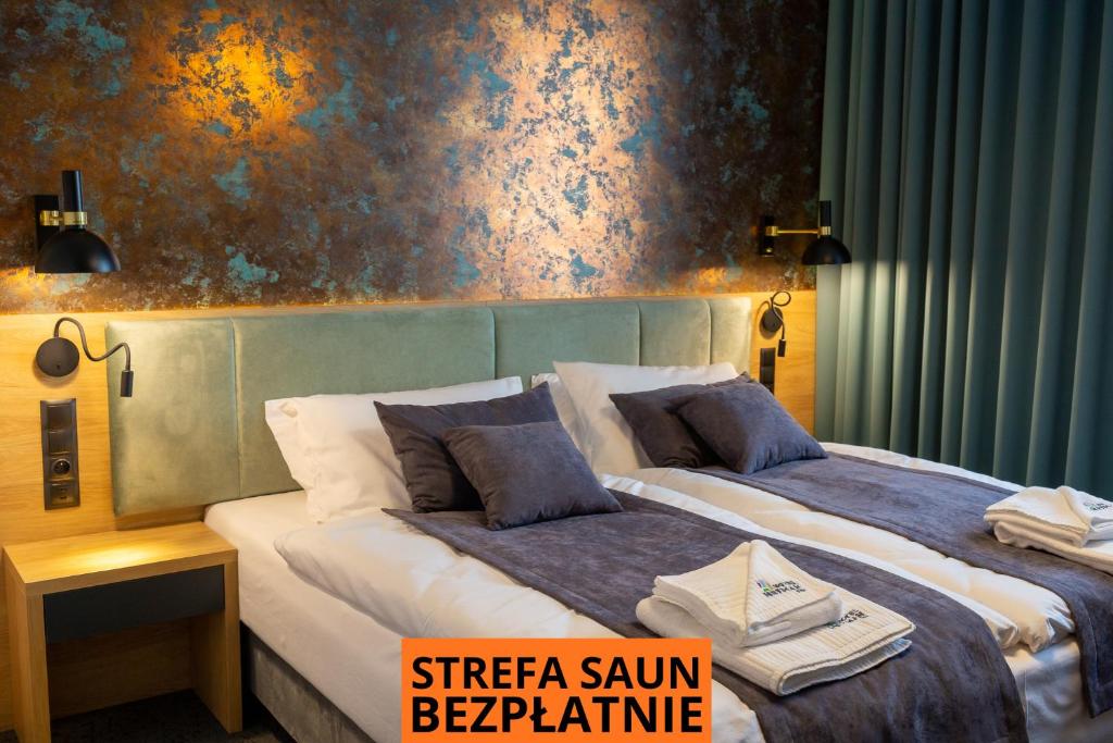 a hotel room with two beds and a painting on the wall at Hotel & SPA Hetman in Siedlce