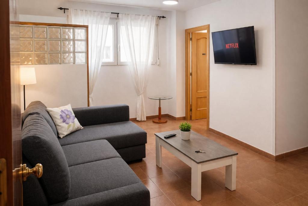 a living room with a couch and a table at Winahost Coslada Av Lisboa in Coslada