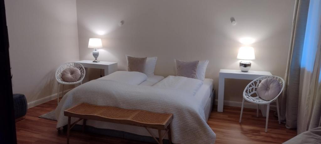 a bedroom with a bed with two chairs and two lights at BALTHAZAR APARTMENT IPHOFEN, klimatisiert, nähe MARKTPLATZ, KNAUF GIPS KG und ConneKT Kitzingen, VDP Weingut Wirsching, TV mirroring 55" Zoll, Wifi, mit kleiner Terrassen in Iphofen