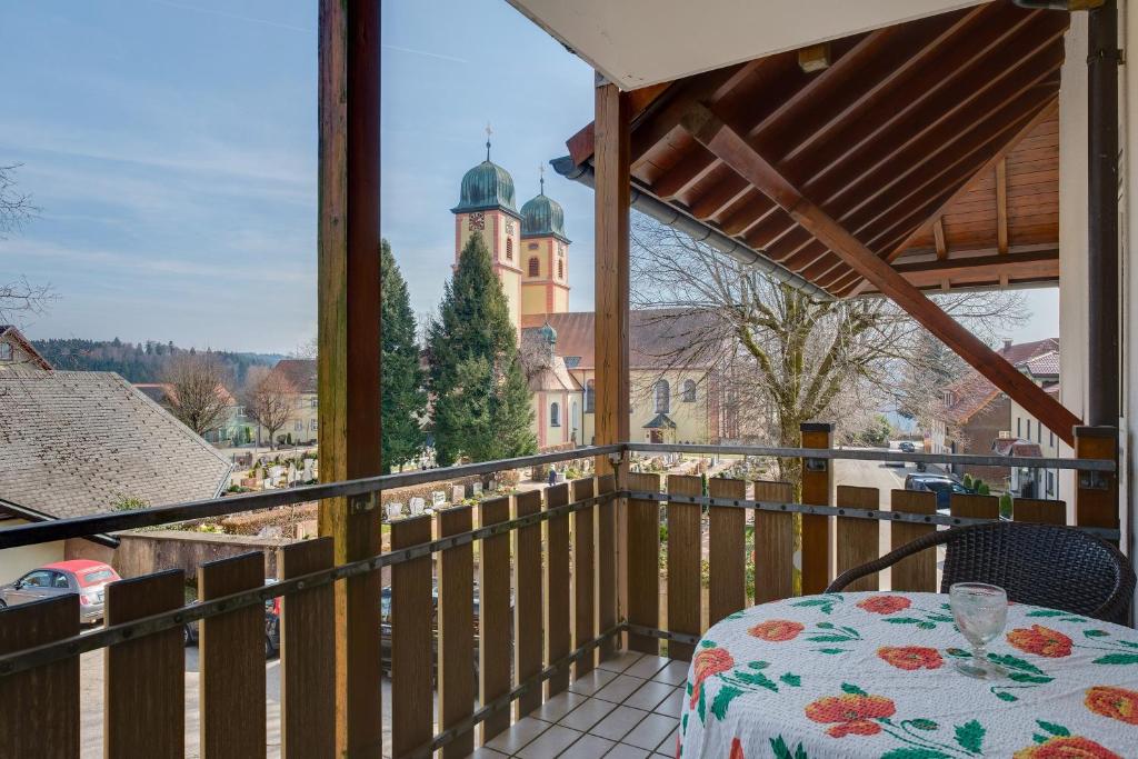 a balcony with a table and a view of a church at Ferienwohnung Christa in Sankt Märgen