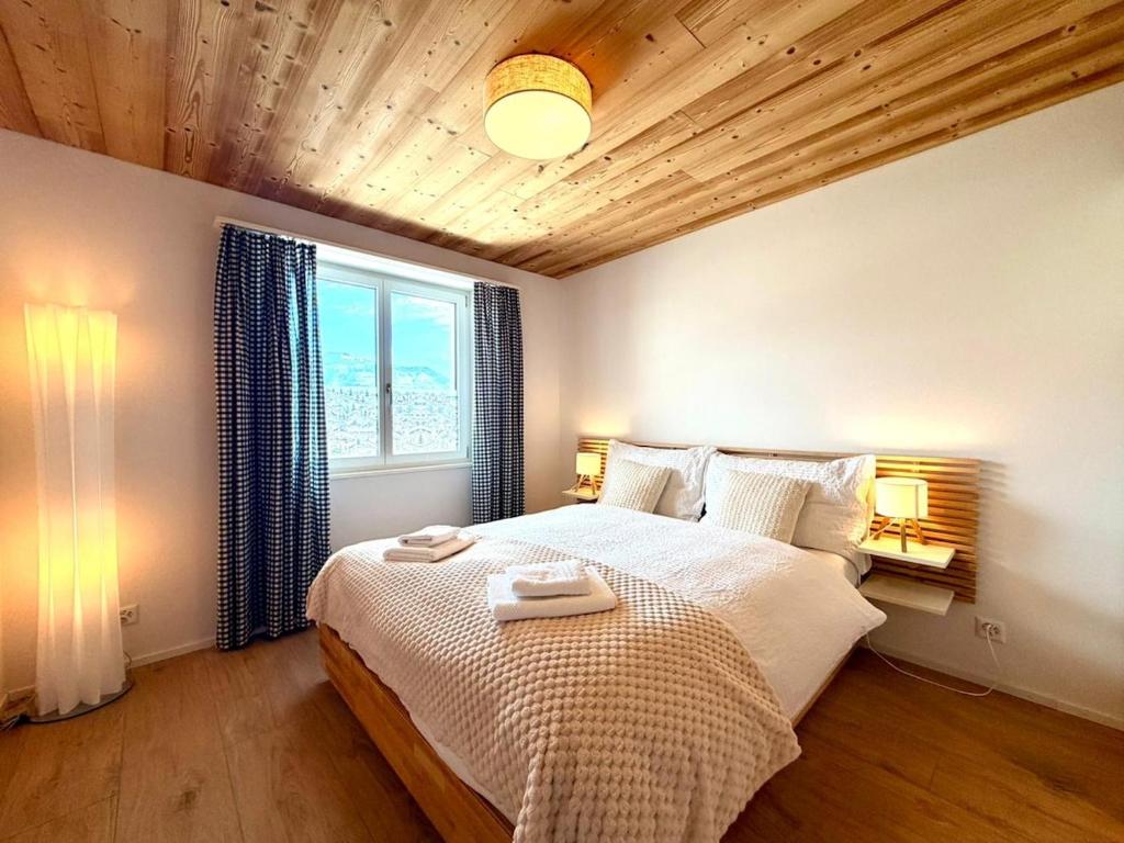a bedroom with a bed with two towels on it at Modernes Apartment - Lakeview Sunnmatte in Leissigen
