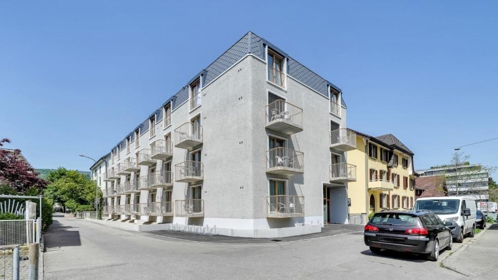 a building with a car parked in front of it at MOOI Apartments Biel in Biel