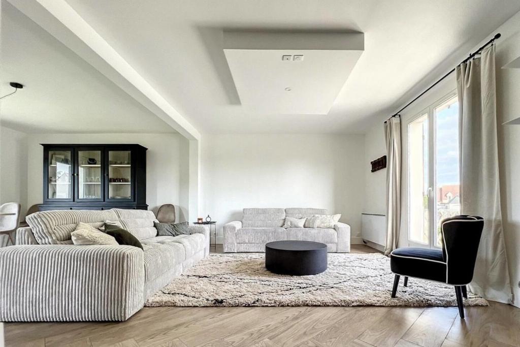 a living room with a couch and a table at Spacious house 300m from the beach in Hermanville-sur-Mer