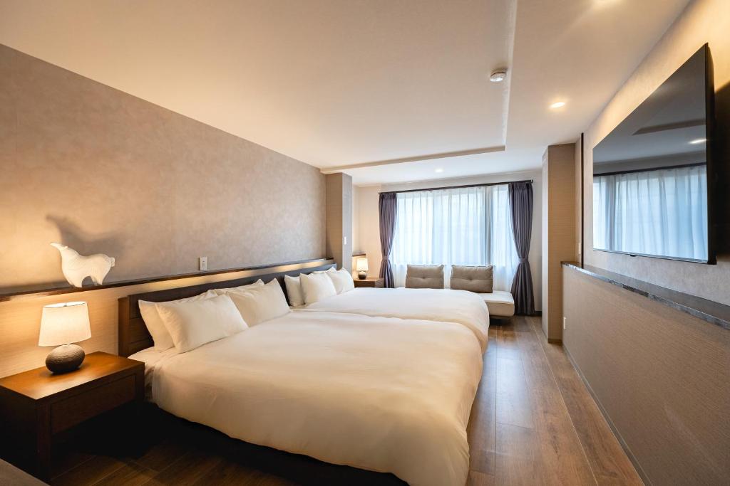 a hotel room with a large bed and a window at The Mita Villa - 2 bed rooms & 3 floors villa with roof garden in Tokyo