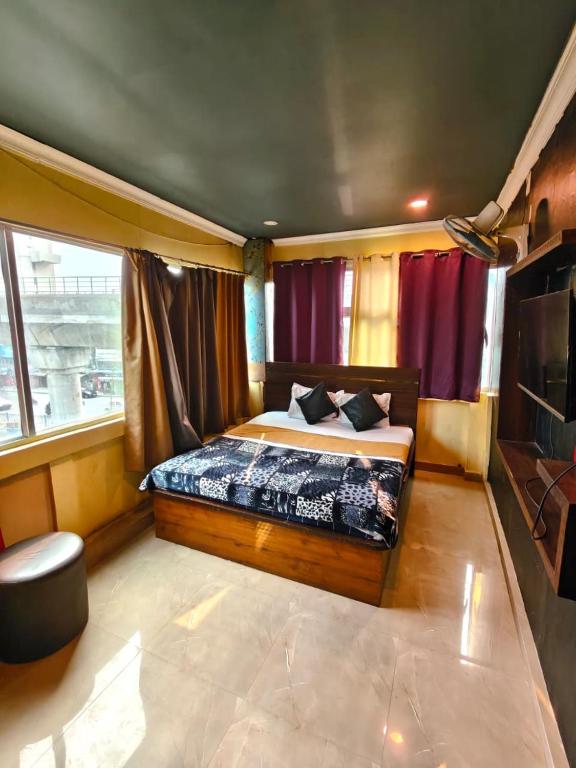 a bedroom with a bed and a large window at Hotel Heavens in Dum-Dum Junction