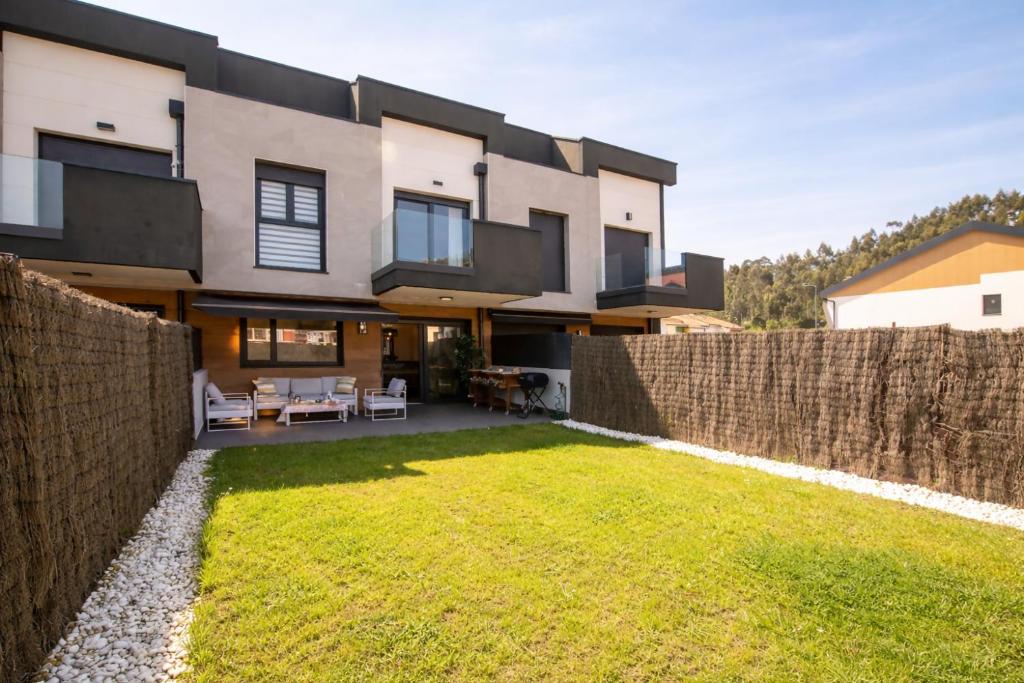 a house with a fence in front of a yard at Ribadesella Casa con Jardín a 2 km Playa – Saelia in Ribadesella