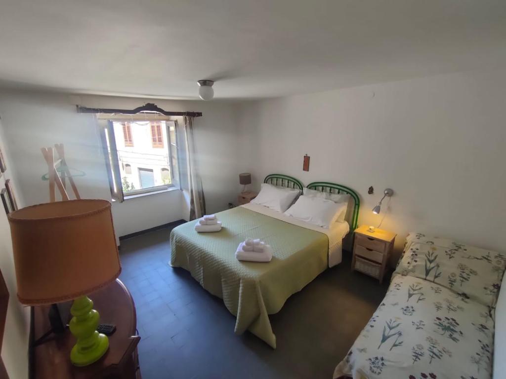 a bedroom with a bed and a chair and a window at A P E house in Polizzi Generosa