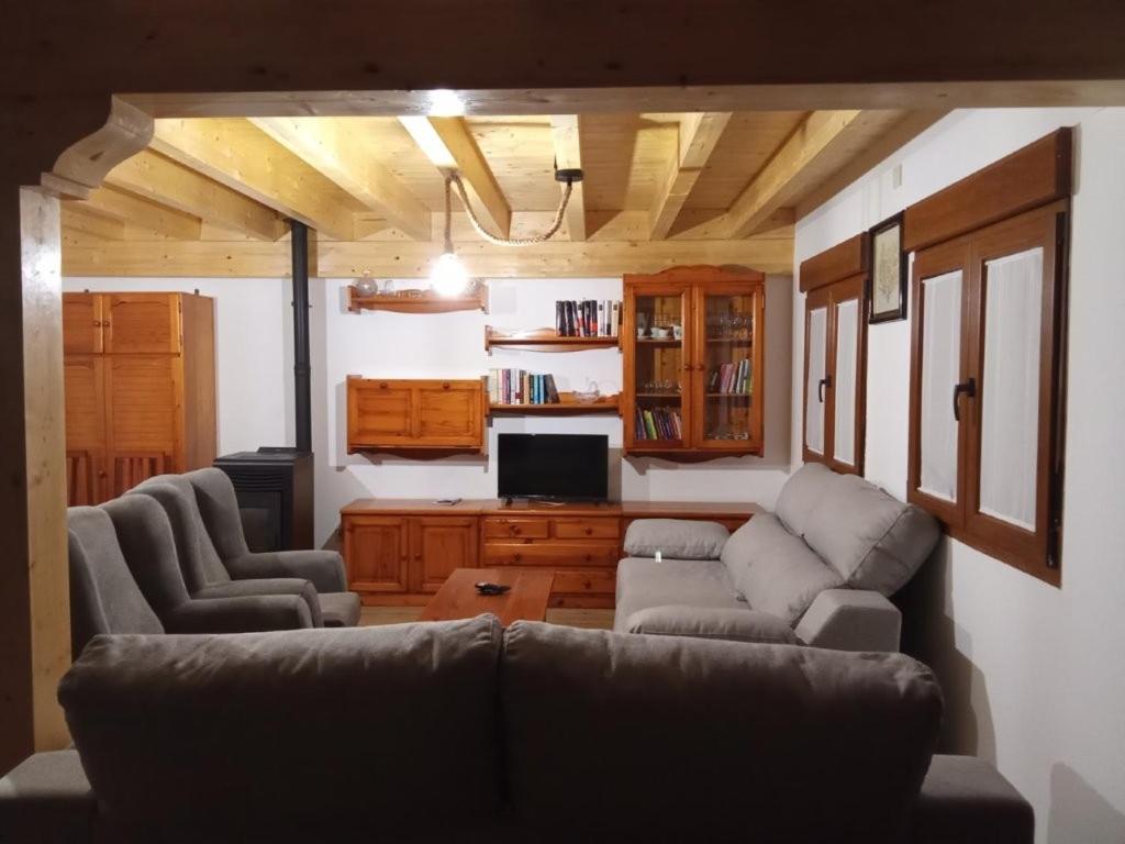 a living room with two couches and a tv at Casa Abuela Antolina in La Horcajada