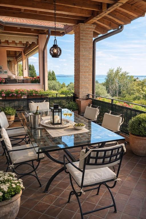 a patio with a glass table and chairs at Sunshine Luxury Apartment - spacious house - Lake View - Pool in Padenghe sul Garda