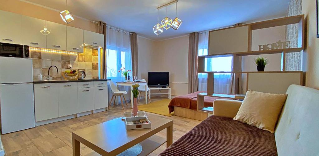 a kitchen and a living room with a couch and a table at Mokka Apartament in Warsaw