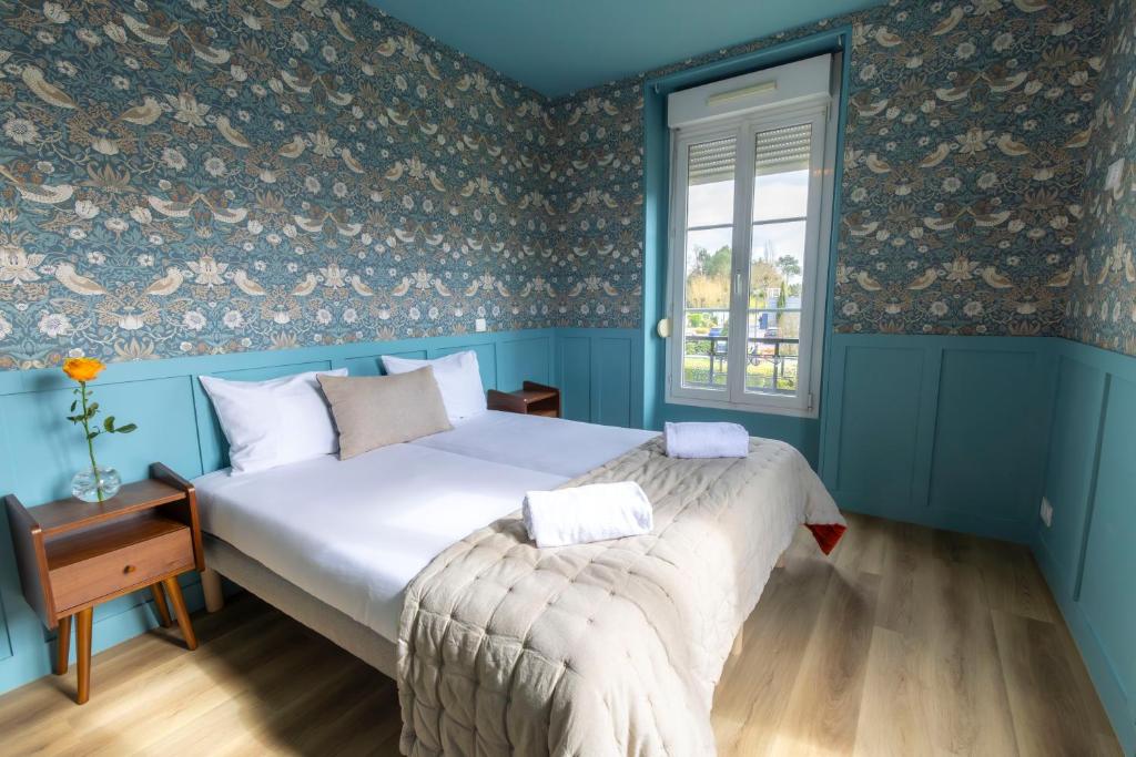 a bedroom with a bed with blue walls and a window at Relais Touraine Sologne in Noyers-sur-Cher