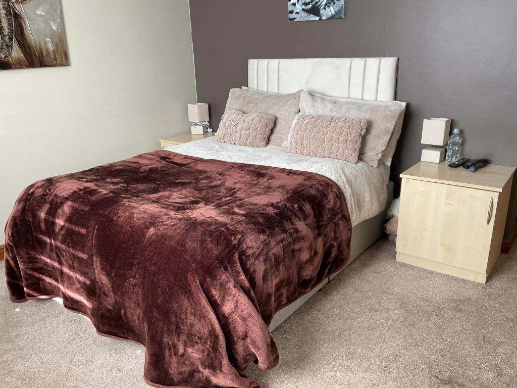 a bedroom with a large bed and two night stands at Cozy Room at Willow House in Leyland
