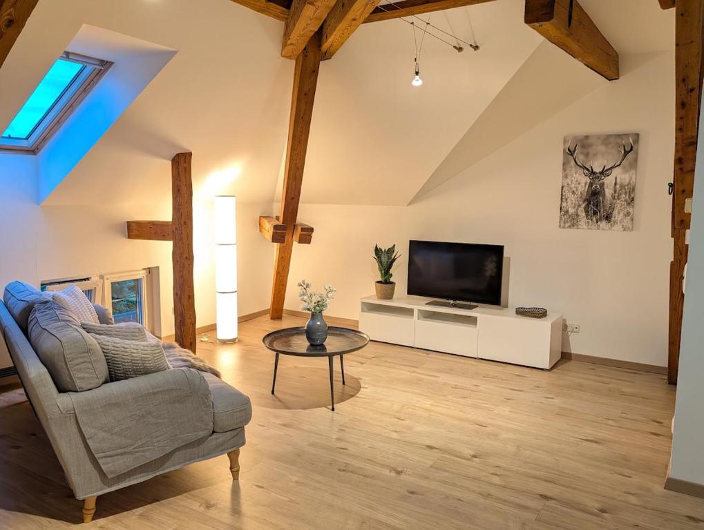 a living room with a couch and a tv at Loft in Weiler in Weiler