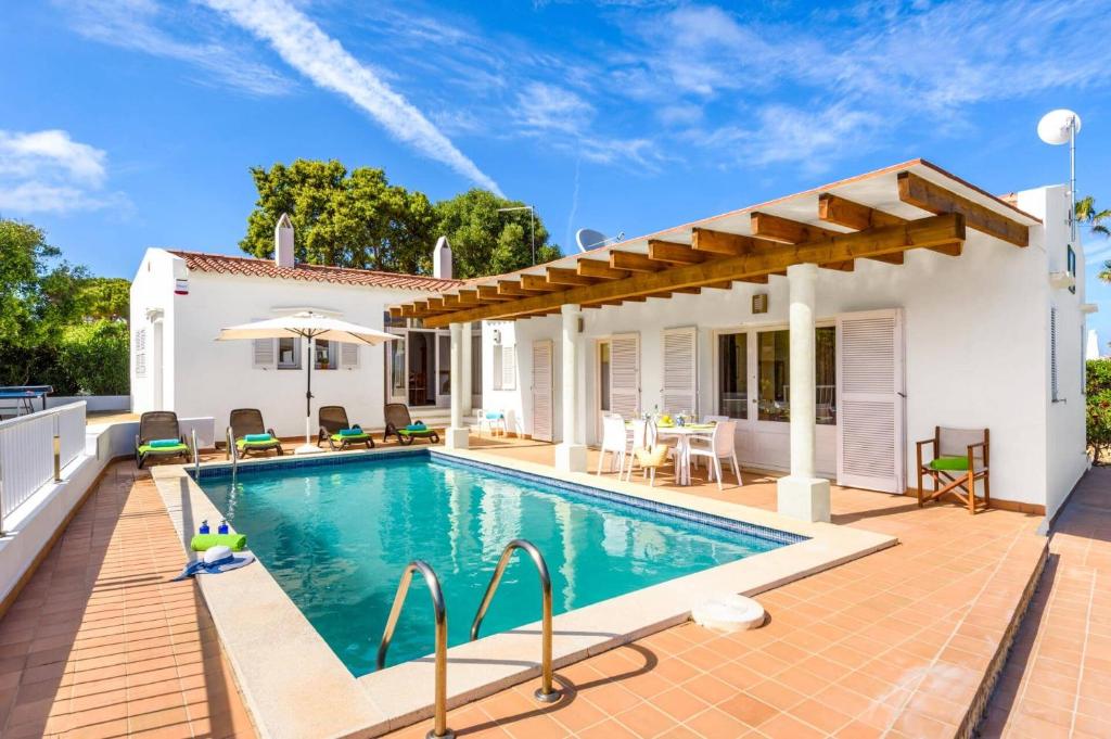 a villa with a swimming pool and a house at Villa Las Rosas by Villa Plus in S'Algar
