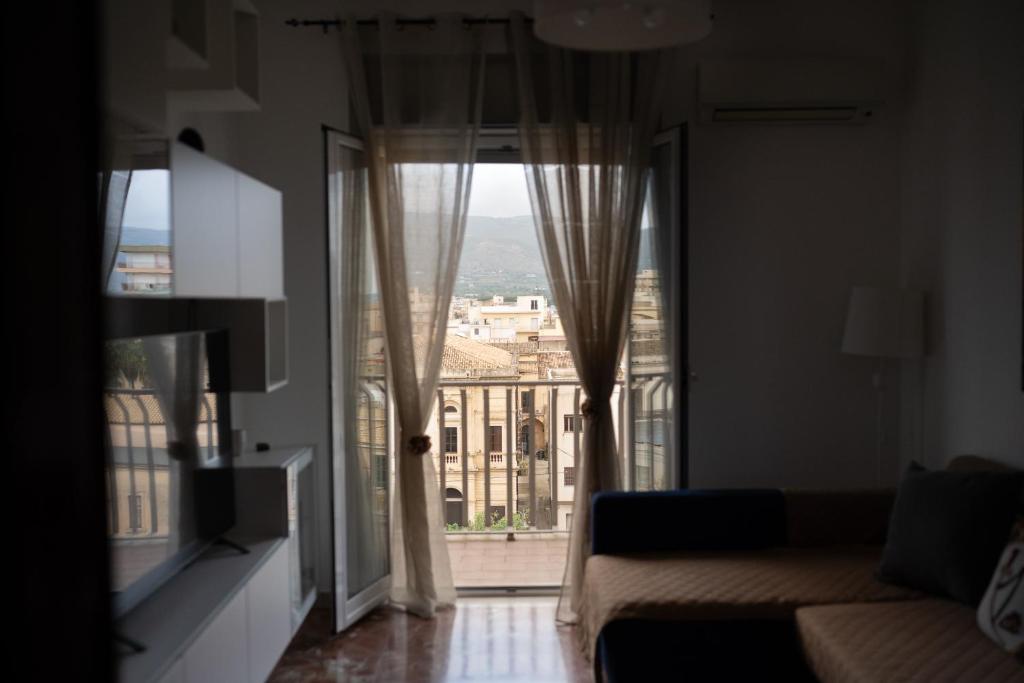 a living room with a couch and a large window at Da DOMITILLA in centro storico con panorama in Avola