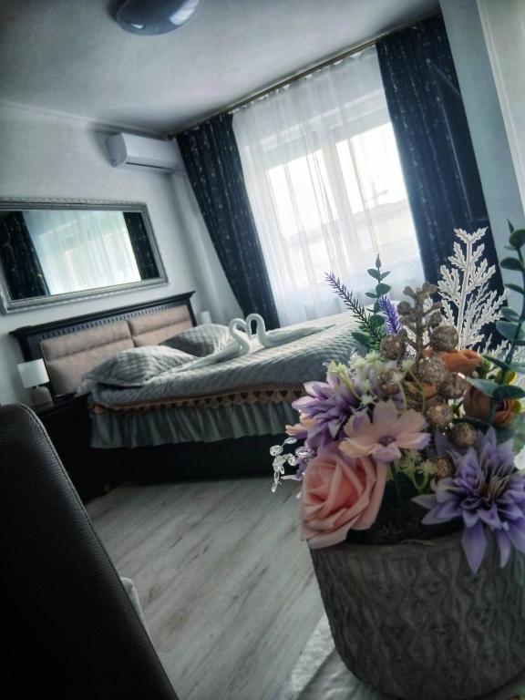 a bedroom with a bed and a vase of flowers at Apartament Premium Militari Parcare Self Check-in in Roşu