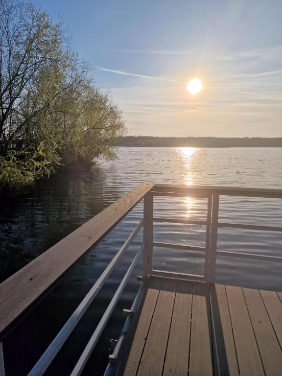 a dock with the sun rising over the water at Casa Cernica in Cernica