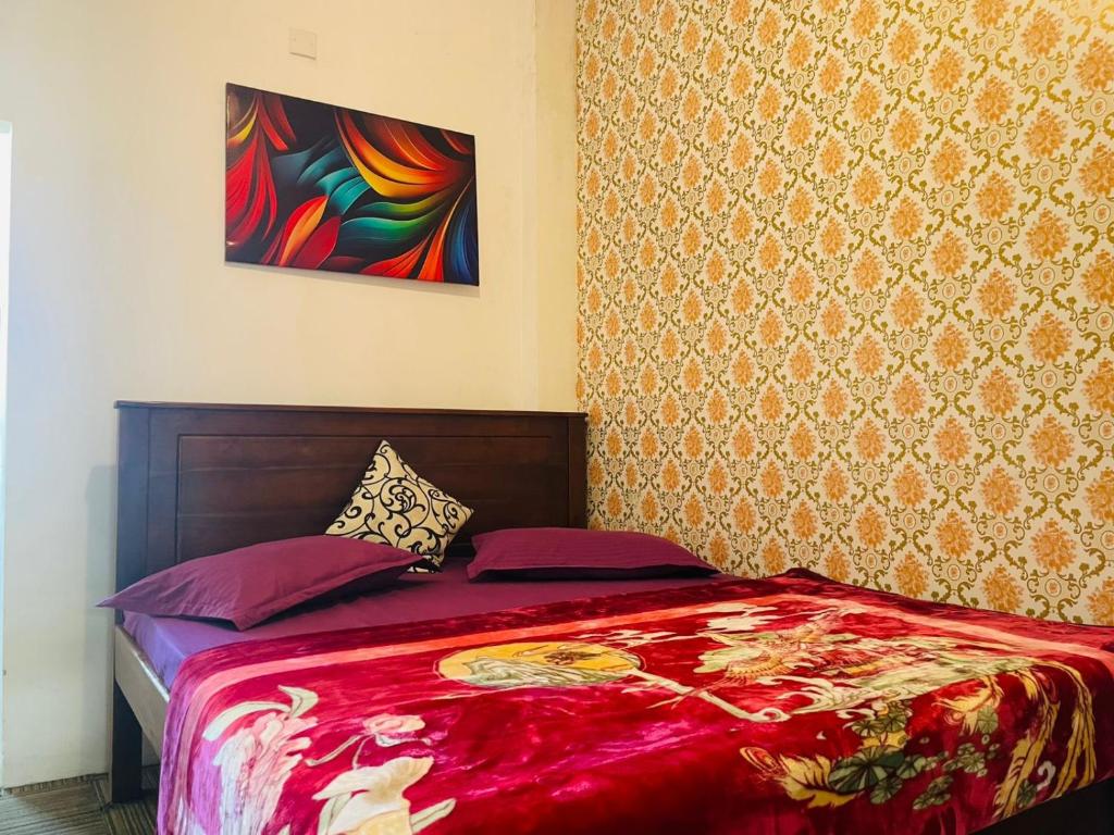 a bedroom with a bed with a red blanket at Ivery guest house in Pattipola