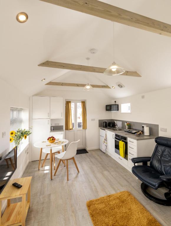 a kitchen and living room with a table and chairs at The Bake House in Worthing