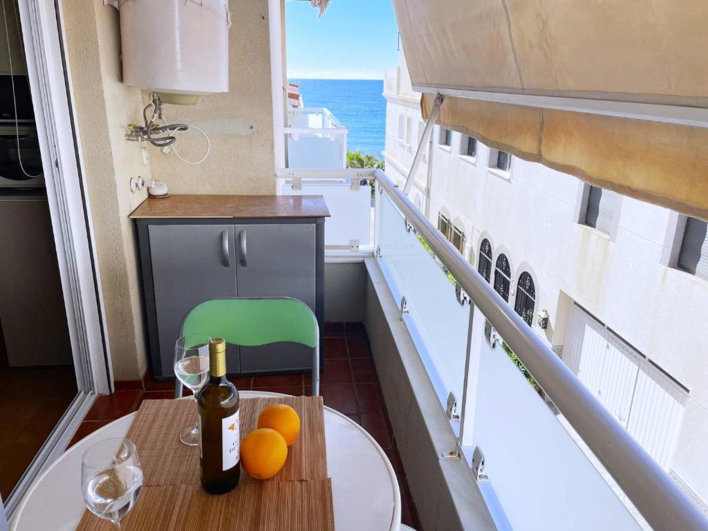 a table with a bottle of wine and oranges on a balcony at Comeback Brisa Serena in Rubite