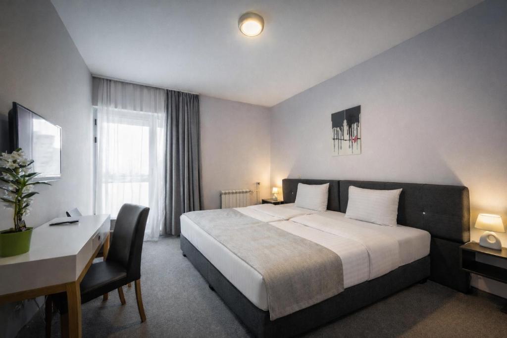 a hotel room with a bed and a desk and a computer at Nobel Inn Hotel in Belgrade