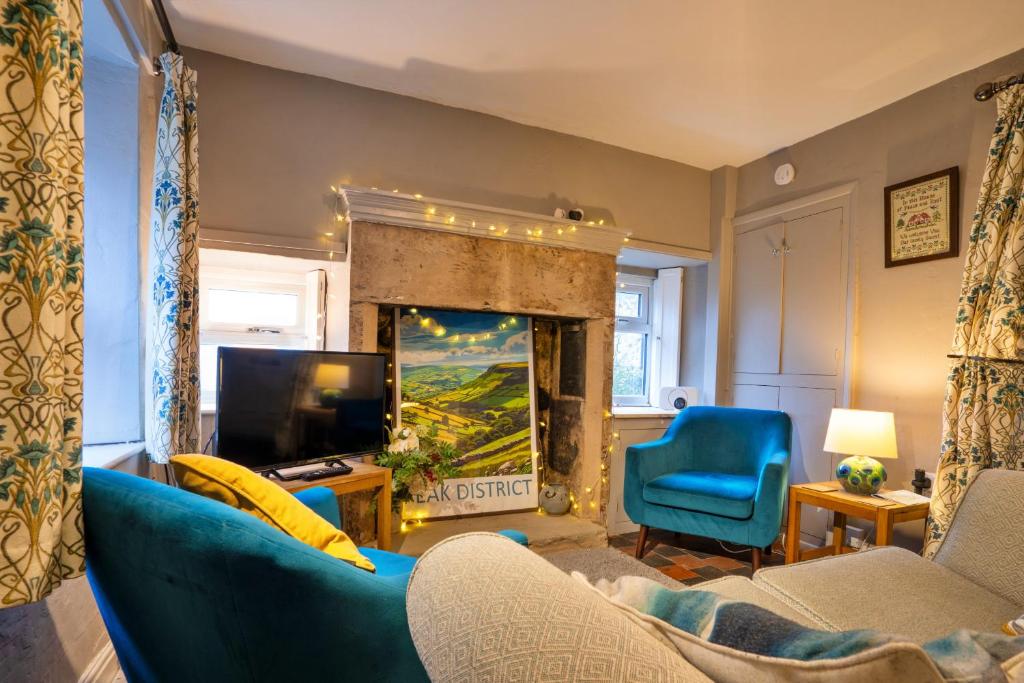 a living room with a blue couch and a fireplace at Finest Retreats - East Bank in Matlock