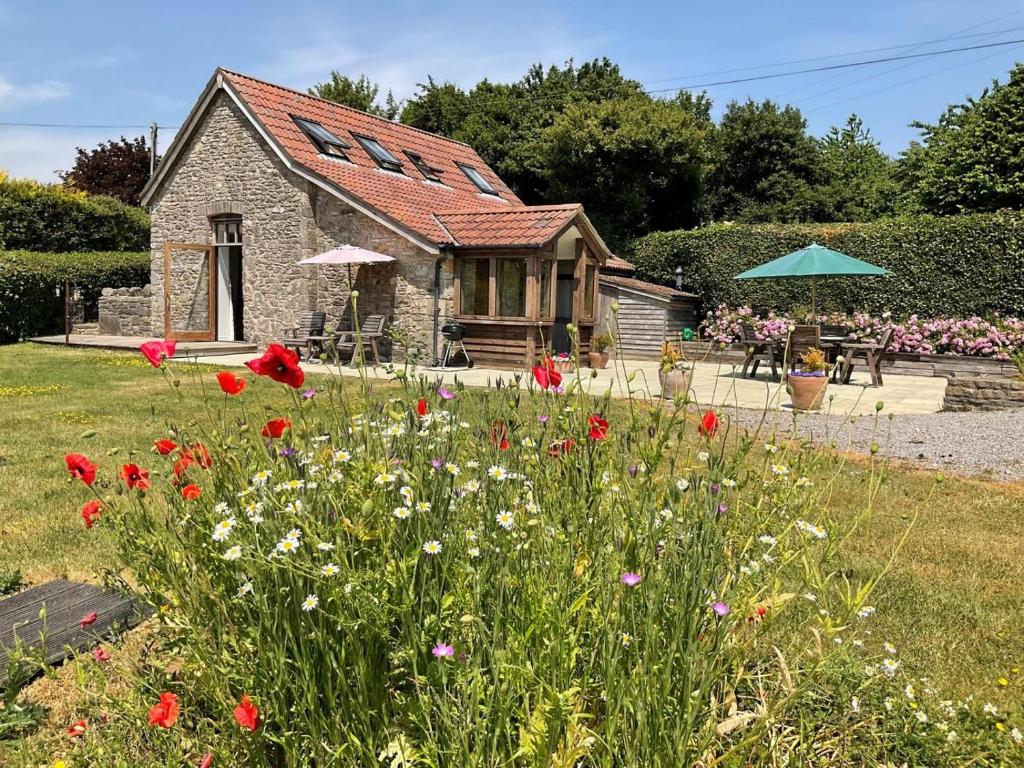 a garden with flowers in front of a house at 2 Bed in Blagdon oc-tforg in Butcombe