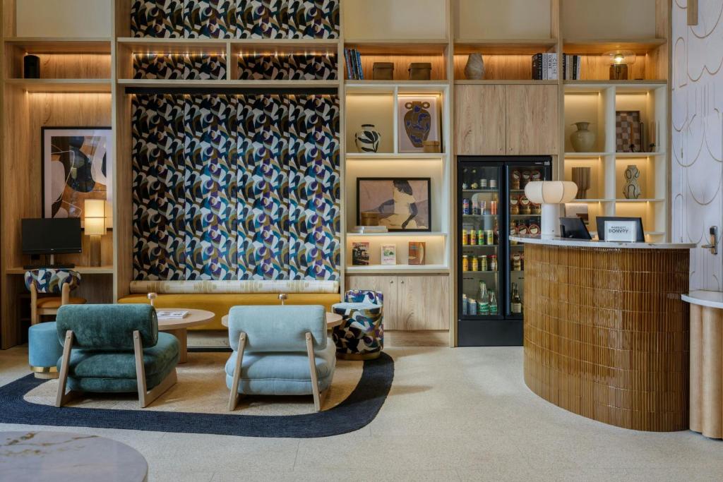 a lobby with two chairs and a bar at Residence Inn by Marriott Lille in Lille