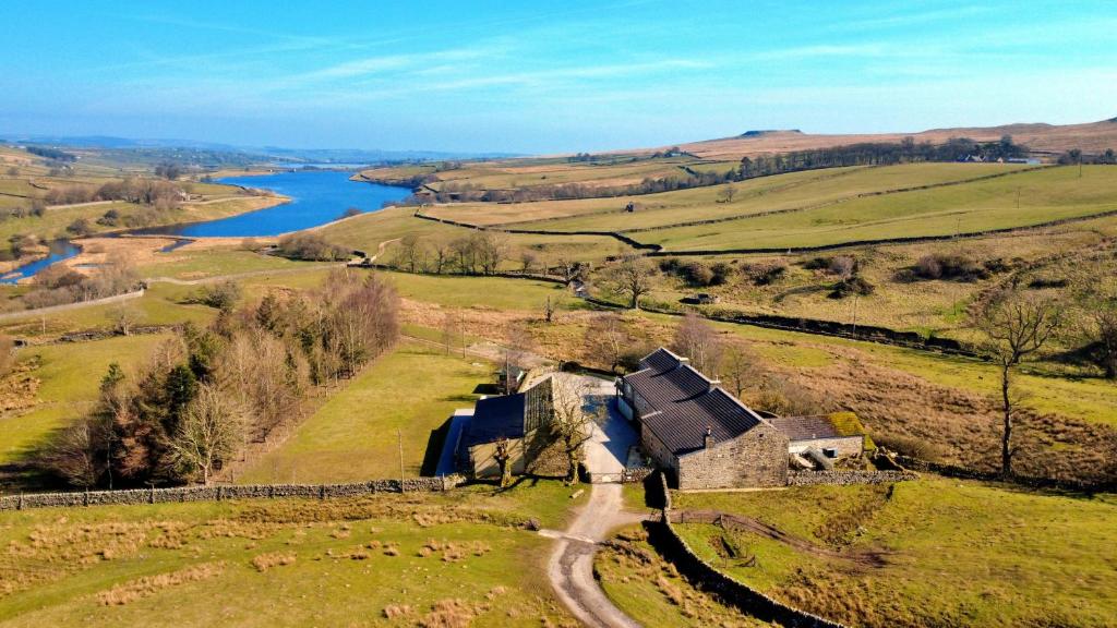 an aerial view of a farm in a field next to a river at Finest Retreats - Blackton Farmhouse in Barnard Castle