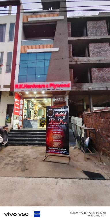 a sign in front of a building with a store at Hotel RK in Ujjain