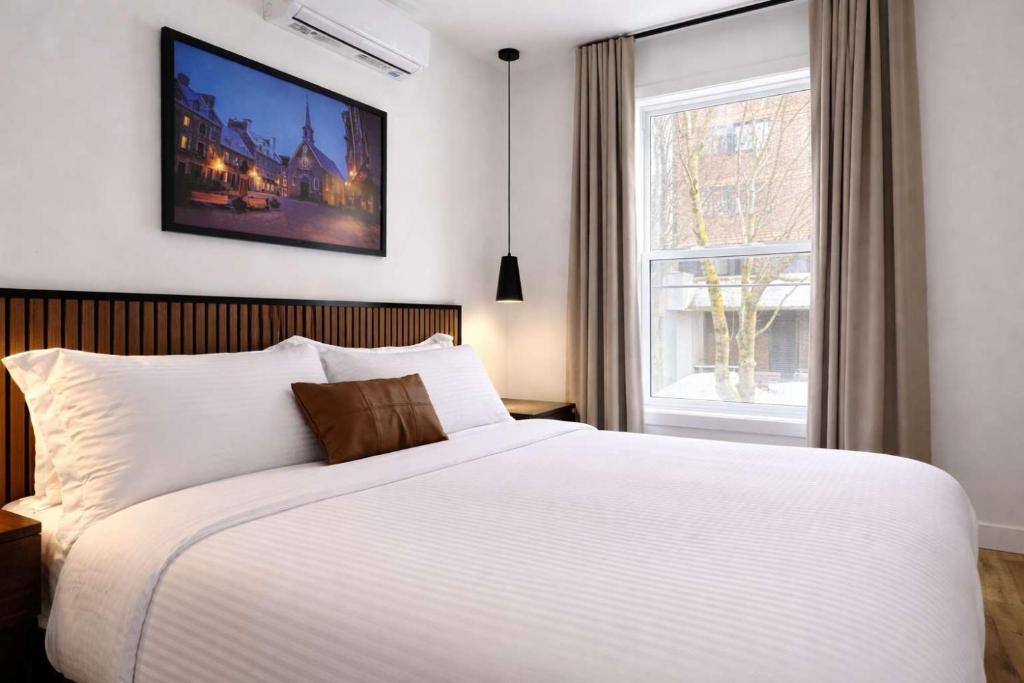 a bedroom with a white bed and a window at Room with a King-Size Bed Downtown Quebec in Quebec City