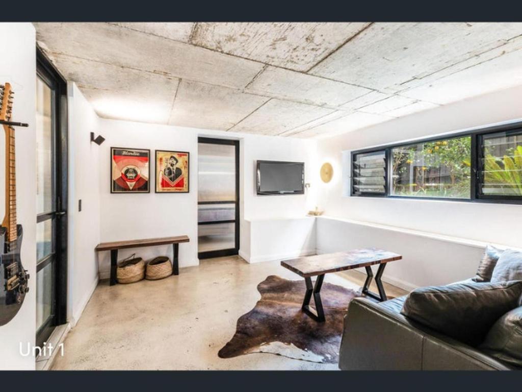a living room with a couch and a table at A spacious Family Retreat near the Beach in Cronulla