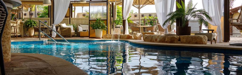 a large swimming pool in a hotel room at Cnaan Village Boutique Hotel & Spa in Had Nes